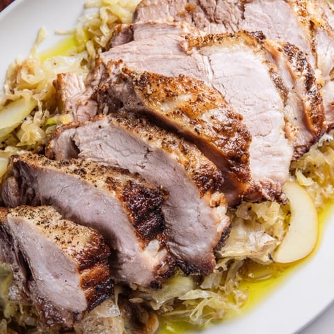 Zart geröstetes Schweinefleisch mit Sauerkraut, perfekt für ein herzhaftes Abendessen.